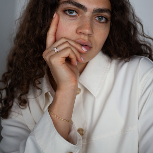 Woman wearing a white coat with gold chain curb bracelet