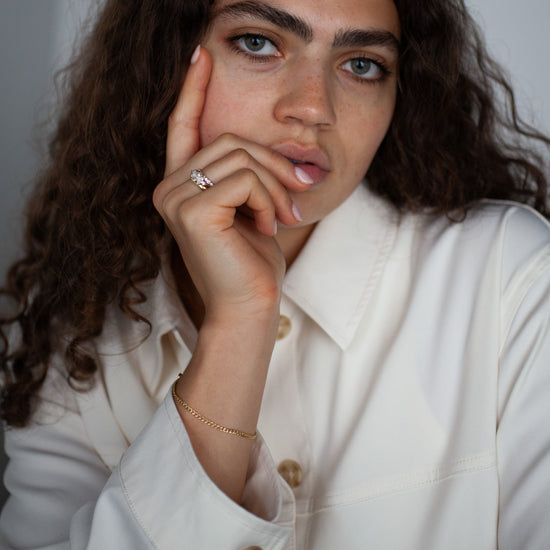 Woman wearing a white coat with gold chain curb bracelet